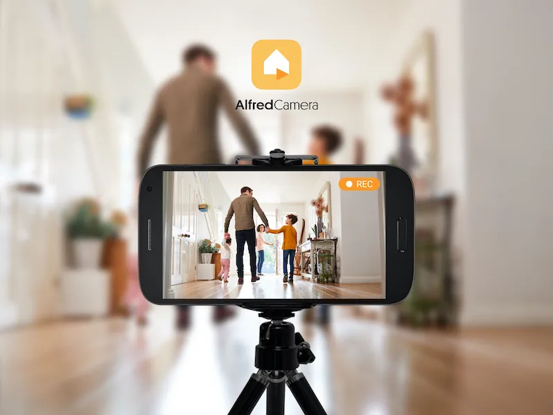 Phone on a tripod recording a father walking with two children, beside the AlfredCamera logo