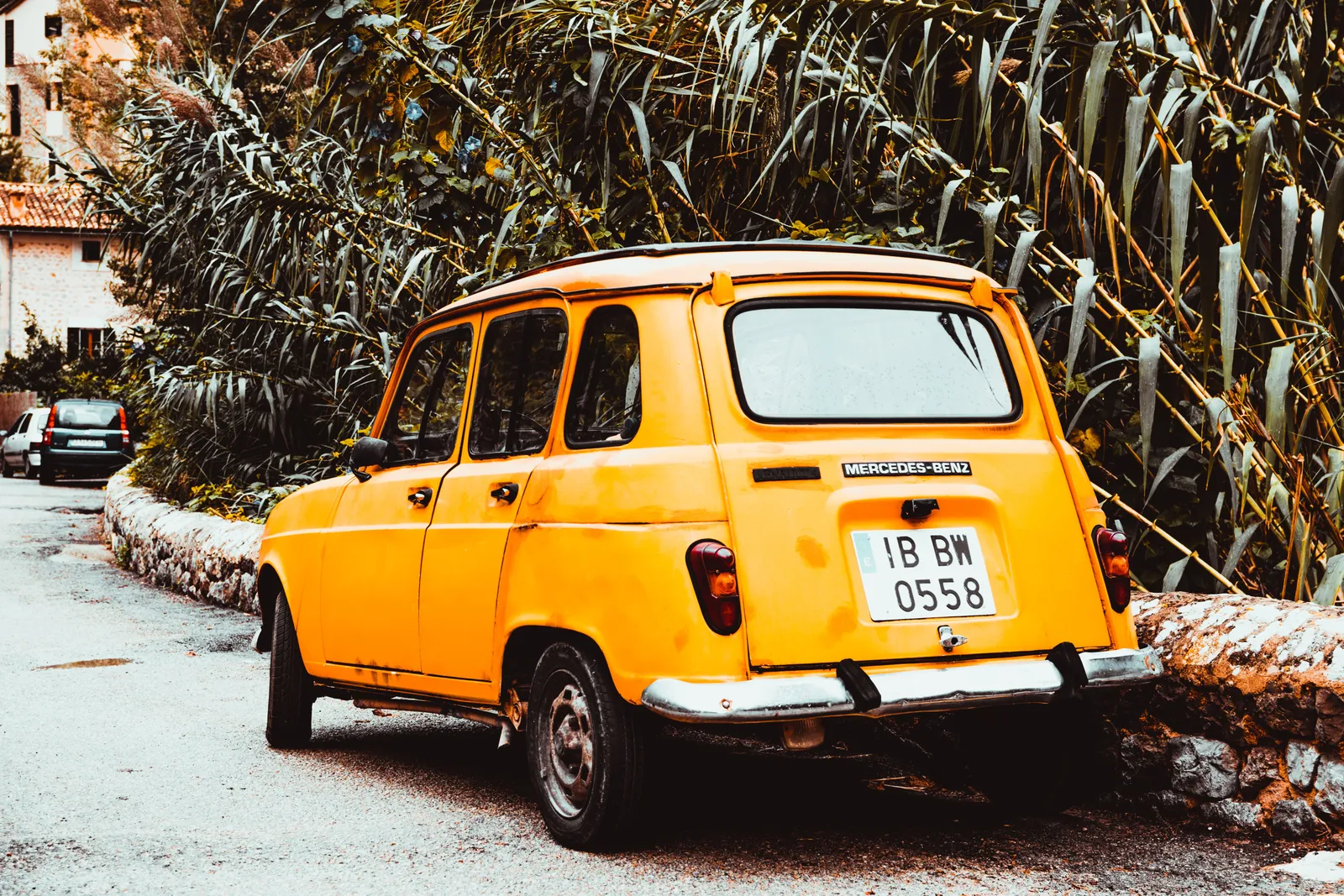 a yellow car parking by a street