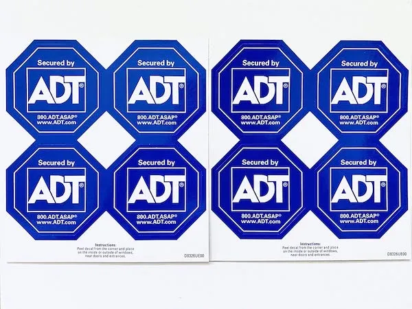 Two sheets of blue octagonal “Secured by ADT” window stickers