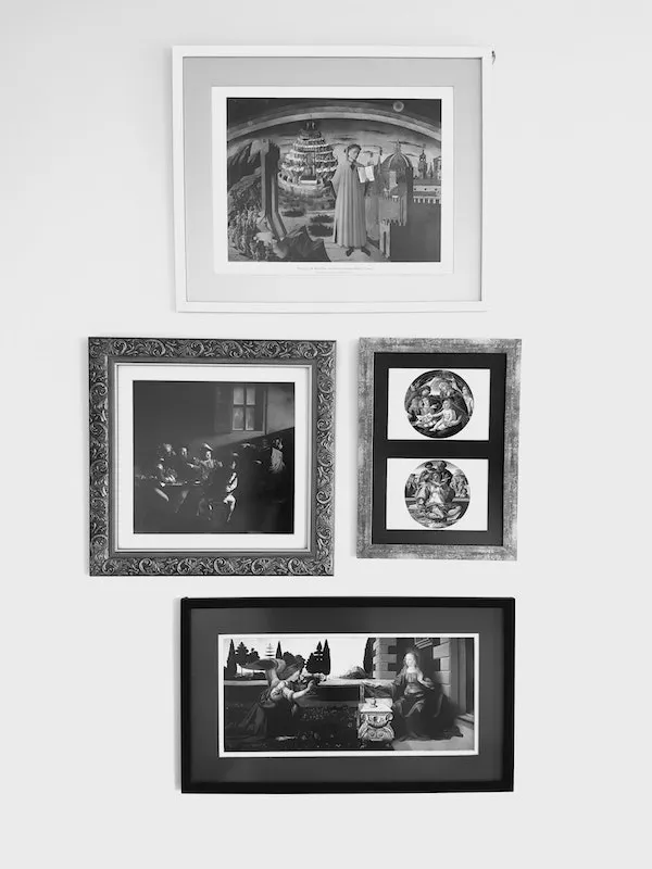 Four framed black-and-white prints hanging together on a white wall.