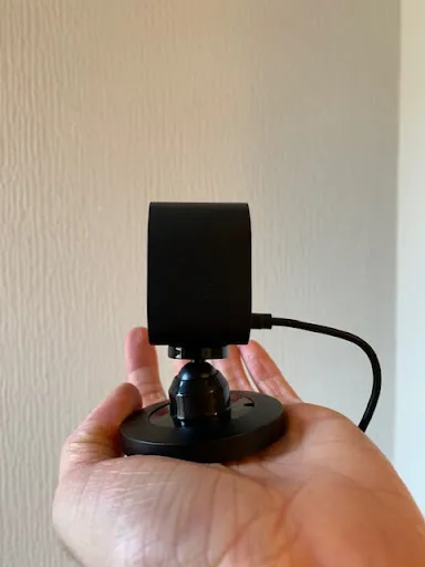 Blink Mini side-on in the palm of hand, with micro USB cable plugged in.