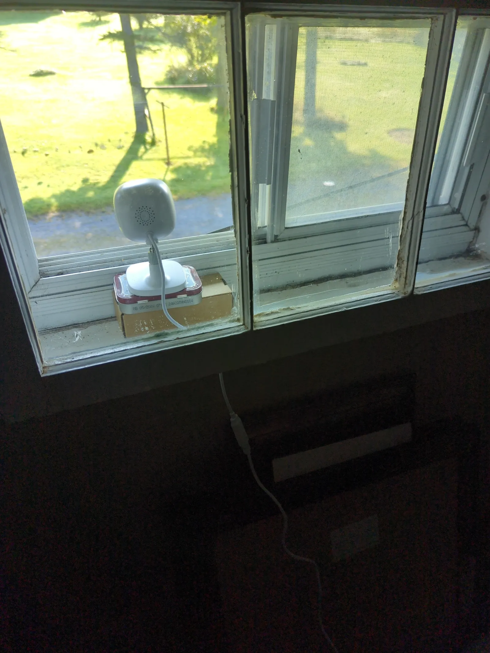 AlfredCam Plus on a windowsill looking out over the yard