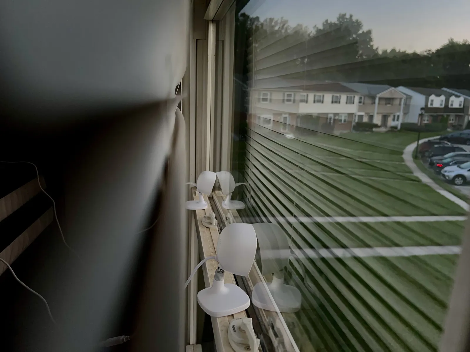 AlfredCam Plus cameras on a windowsill looking out over a parking area.
