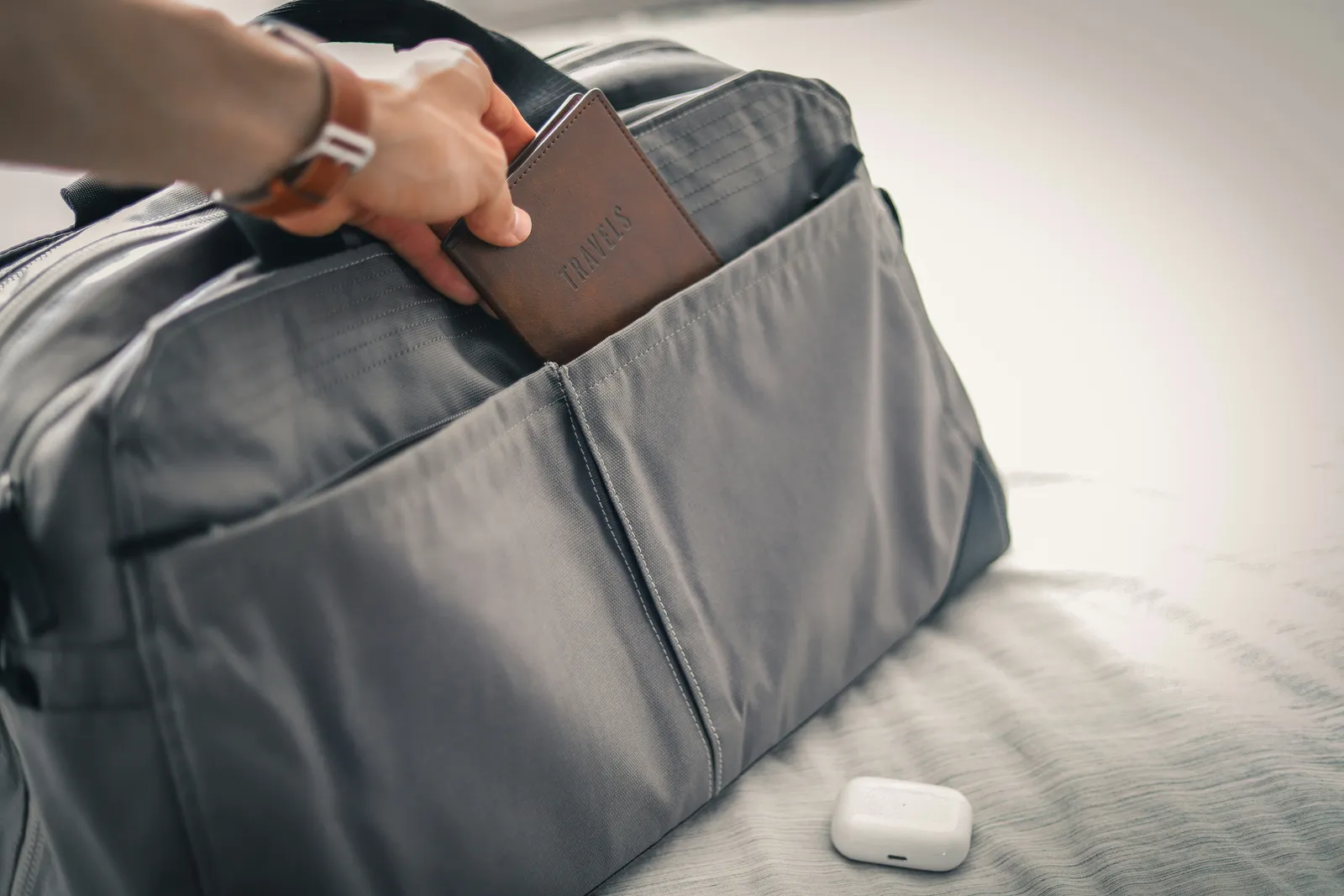 hand storing passport on luggage